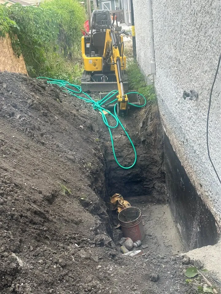 Narrow excavation beside a concrete wall