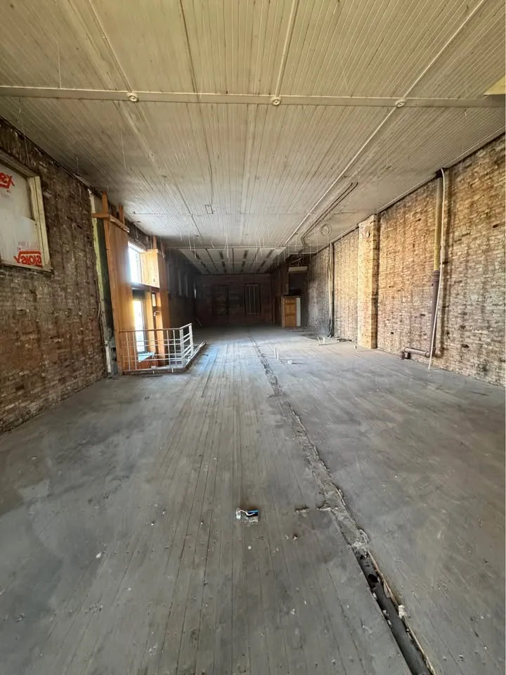 Long room cleared to studs and concrete floor
