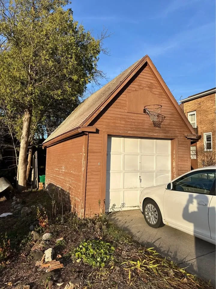 Detached wood garage beside a driveway