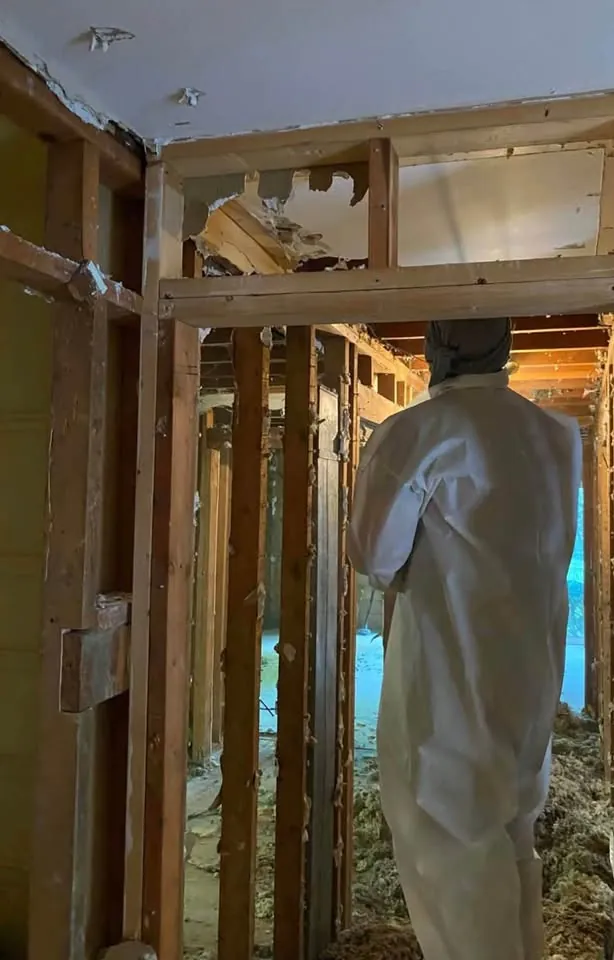 Worker inspecting exposed interior framing