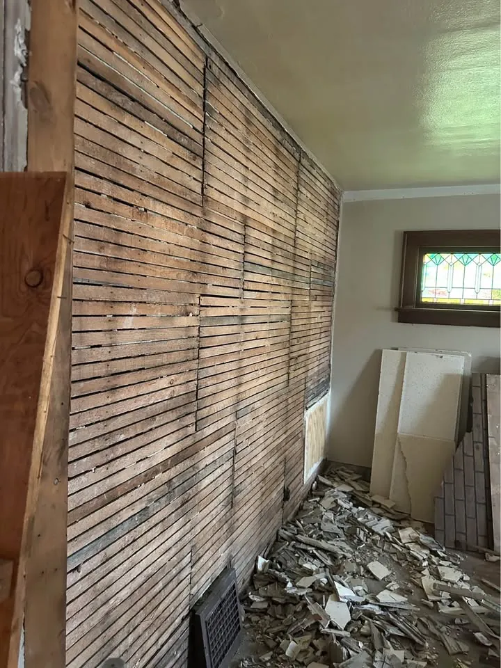Interior wall opened to exposed wood lath